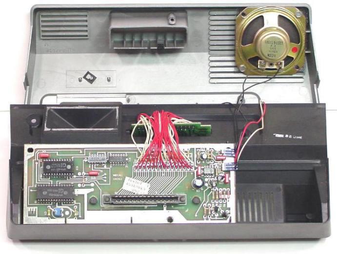 Opened enclosure with loudspeaker, circuit board, and cartridge-slot wiring.