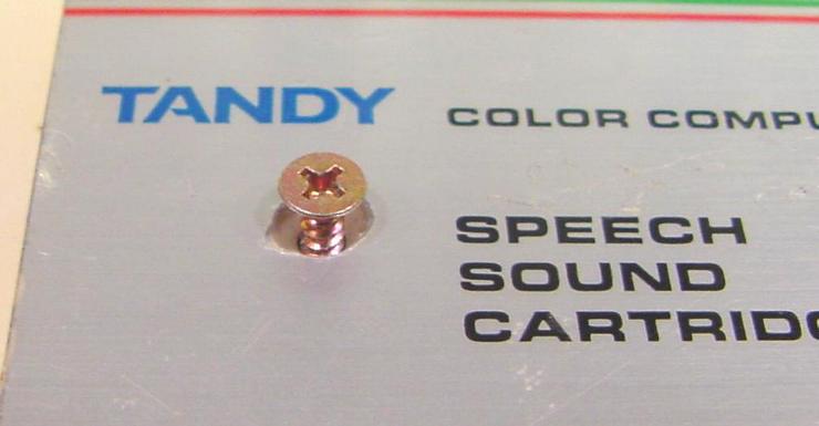 Case screw concealed beneath the label